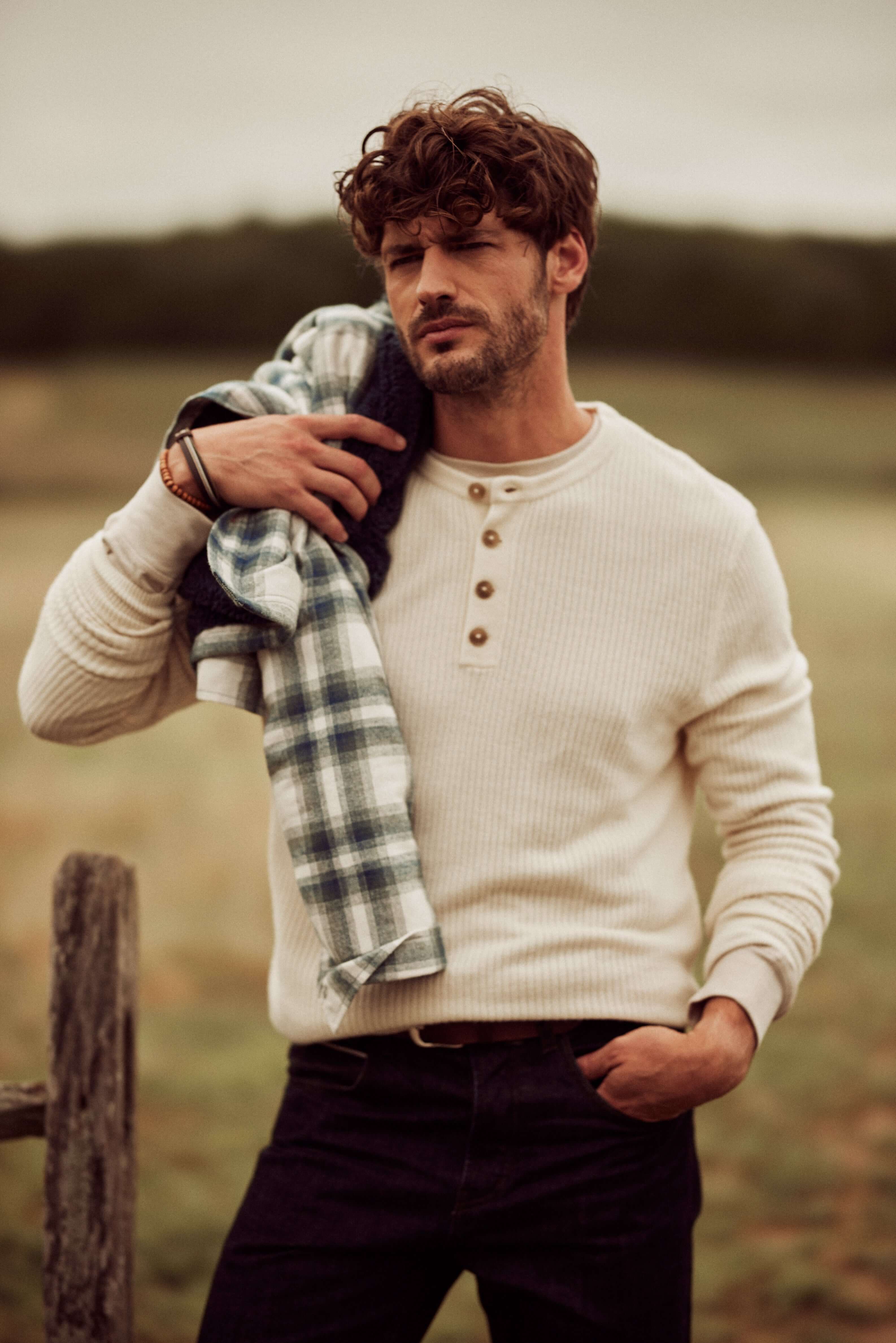 Soft Touch Vertical Stitch Sweater in Natural worn by a man, showcasing a classic henley style in a natural setting.