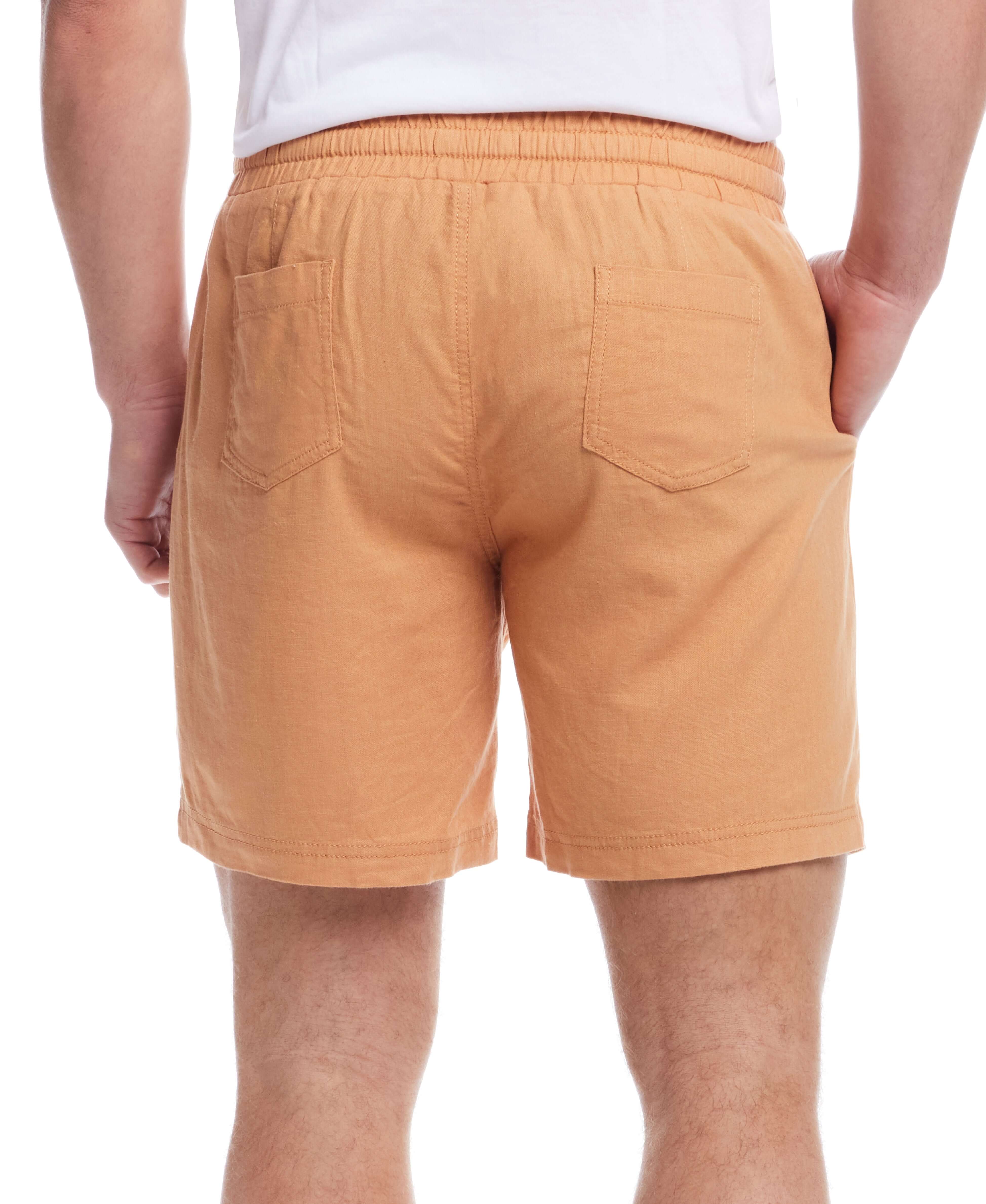 Back view of 7" linen shorts in Biscuit color with elastic waistband and side pockets.