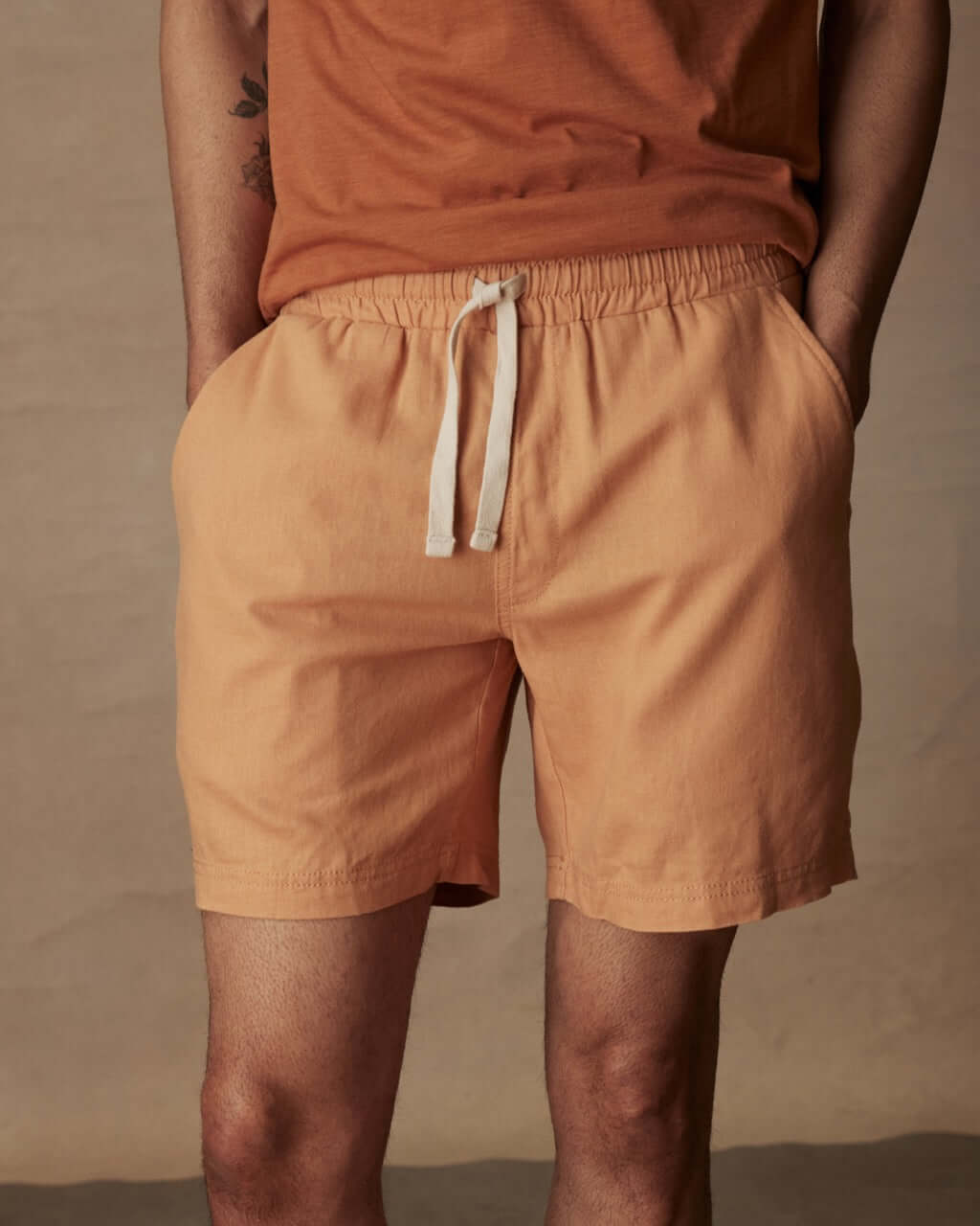 Men's 7" linen shorts in biscuit color with elastic waistband and adjustable drawstring, perfect for casual summer wear.