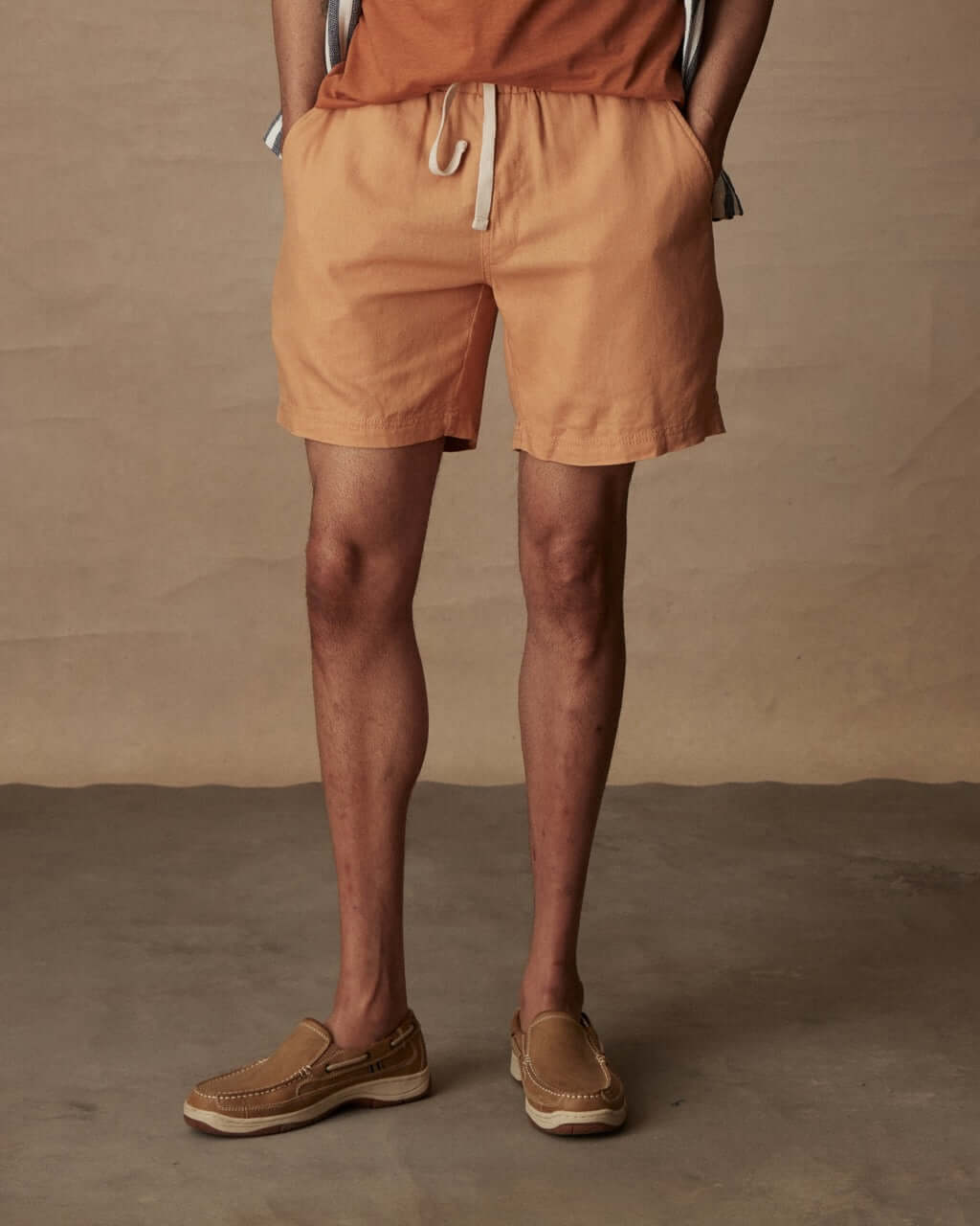 7" linen shorts in biscuit, featuring an elastic waist and adjustable drawcord for comfort.