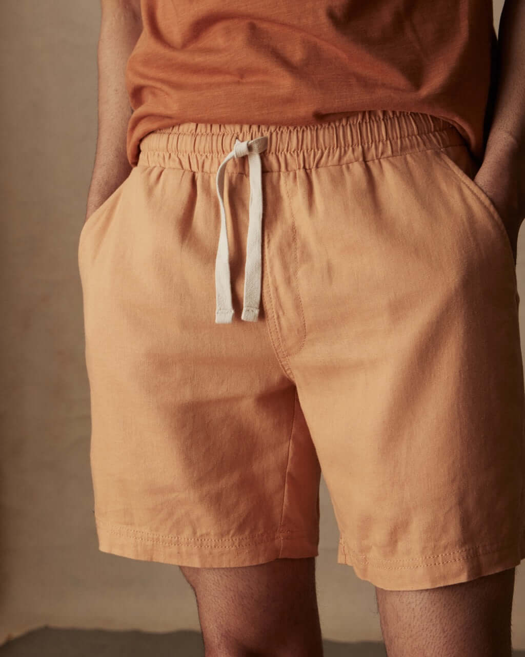 7-inch linen shorts in biscuit color with elastic waist and adjustable drawstring, perfect for a breezy day.