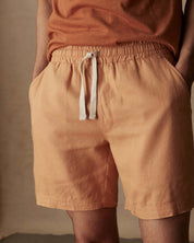 7-inch linen shorts in biscuit color with elastic waist and adjustable drawstring, perfect for a breezy day.
