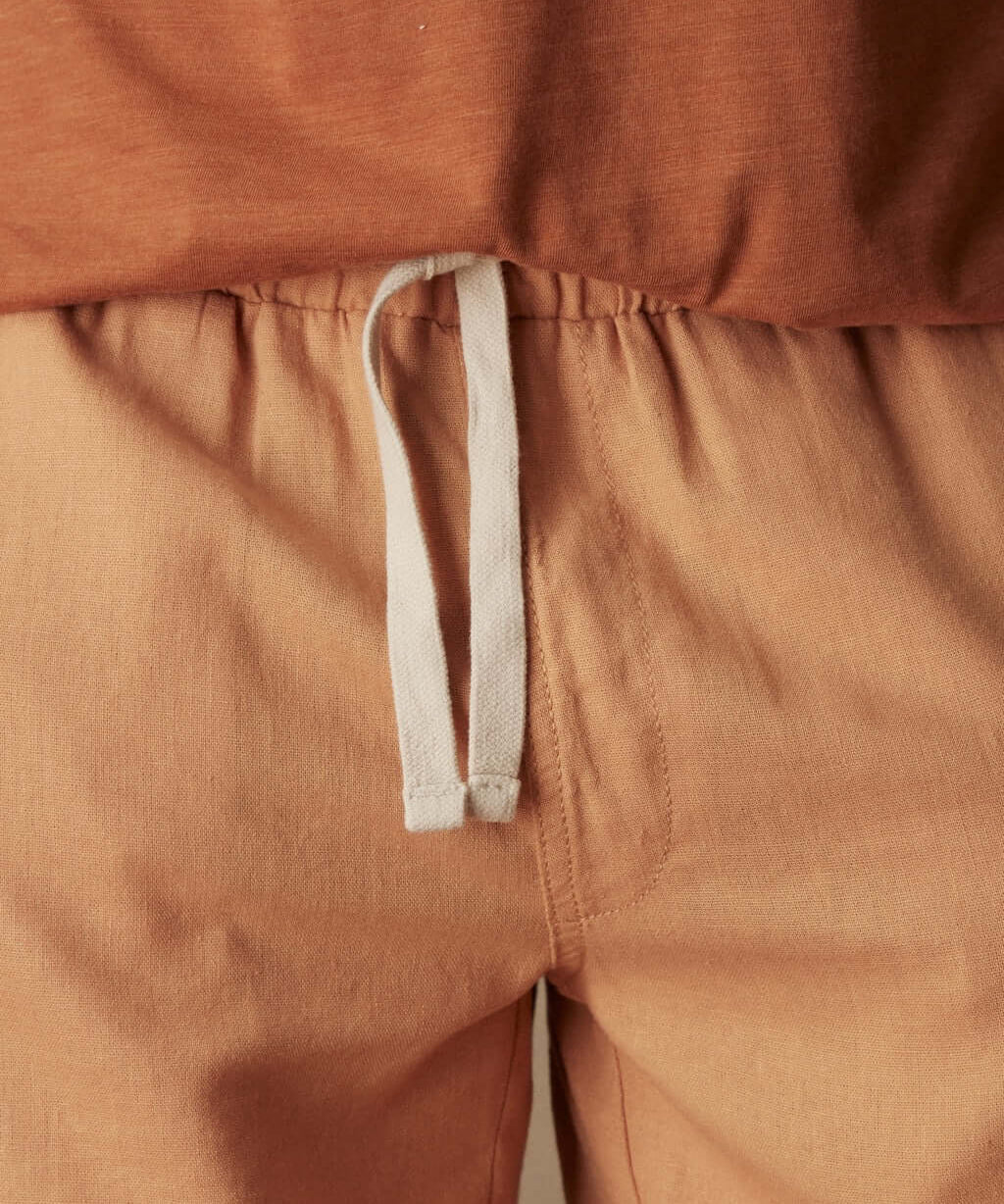 Close-up of 7" linen shorts in biscuit with adjustable drawstring waist and soft fabric texture.