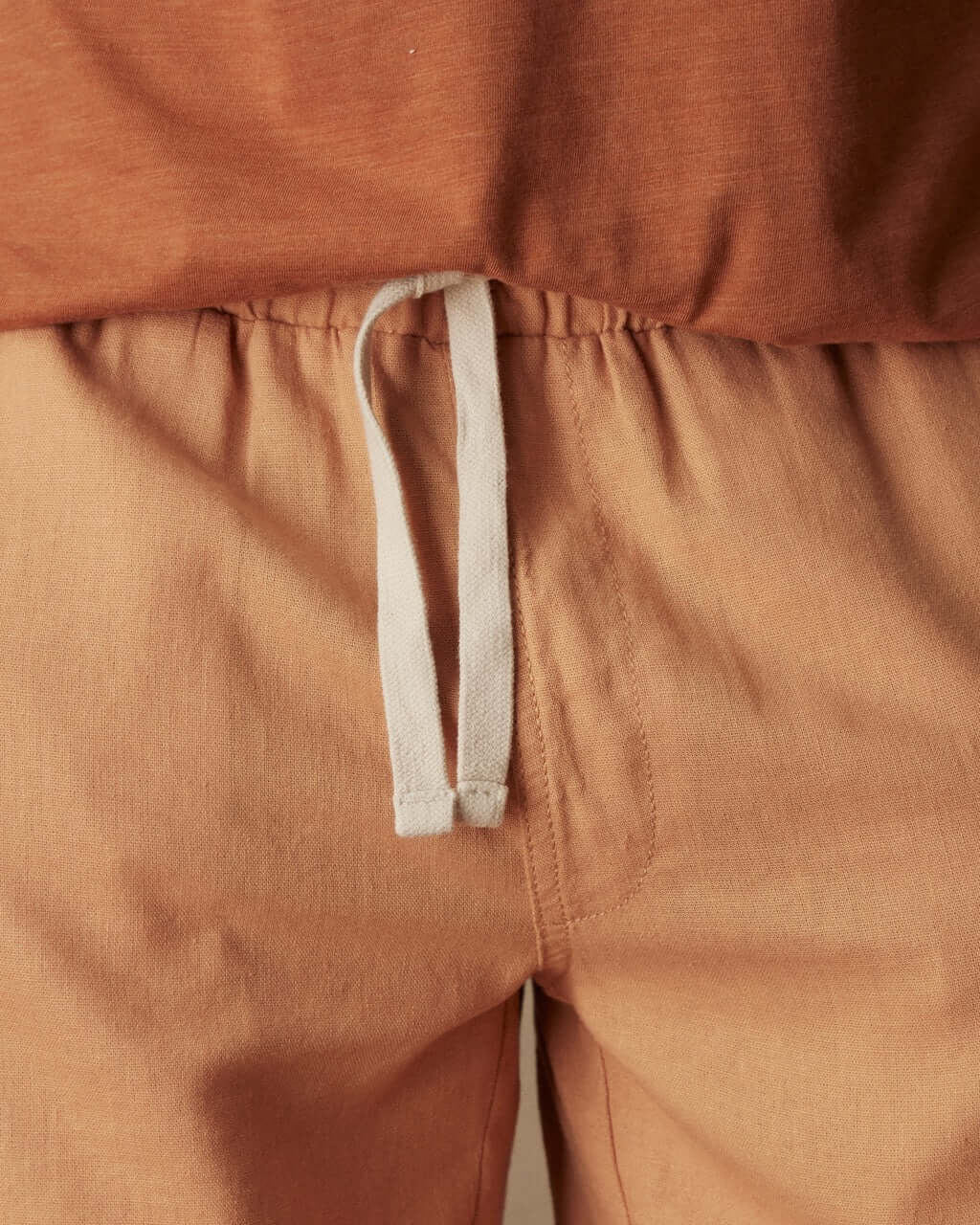 Close-up of 7" linen shorts in biscuit with adjustable drawstring waist and soft fabric texture.