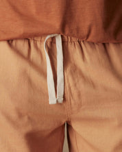 Close-up of 7" linen shorts in biscuit with adjustable drawstring waist and soft fabric texture.