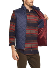 Man in a navy diamond quilted vest with a striped shirt, showcasing the inside pocket and comfortable fit.