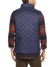 Back view of a man in a navy diamond quilted vest, showcasing its lightweight design and classic fit.