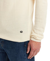 Close-up of a man's hand on the Soft Touch Vertical Stitch Sweater in Natural, showcasing the ribbed texture and logo detail.