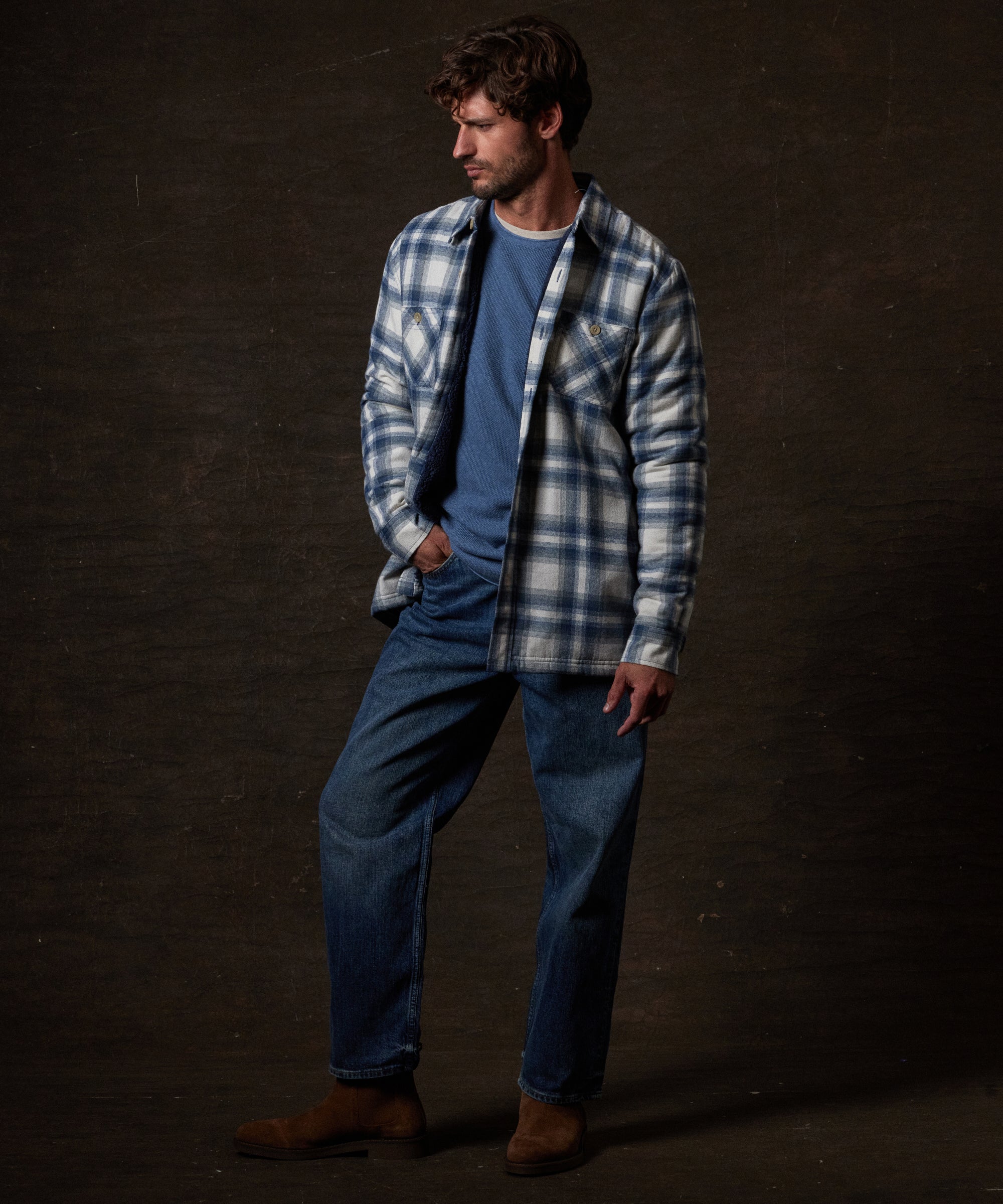 Sherpa Lined Flannel Shirt Jacket in Iron Blue worn by a model with a relaxed fit over a blue shirt and jeans.
