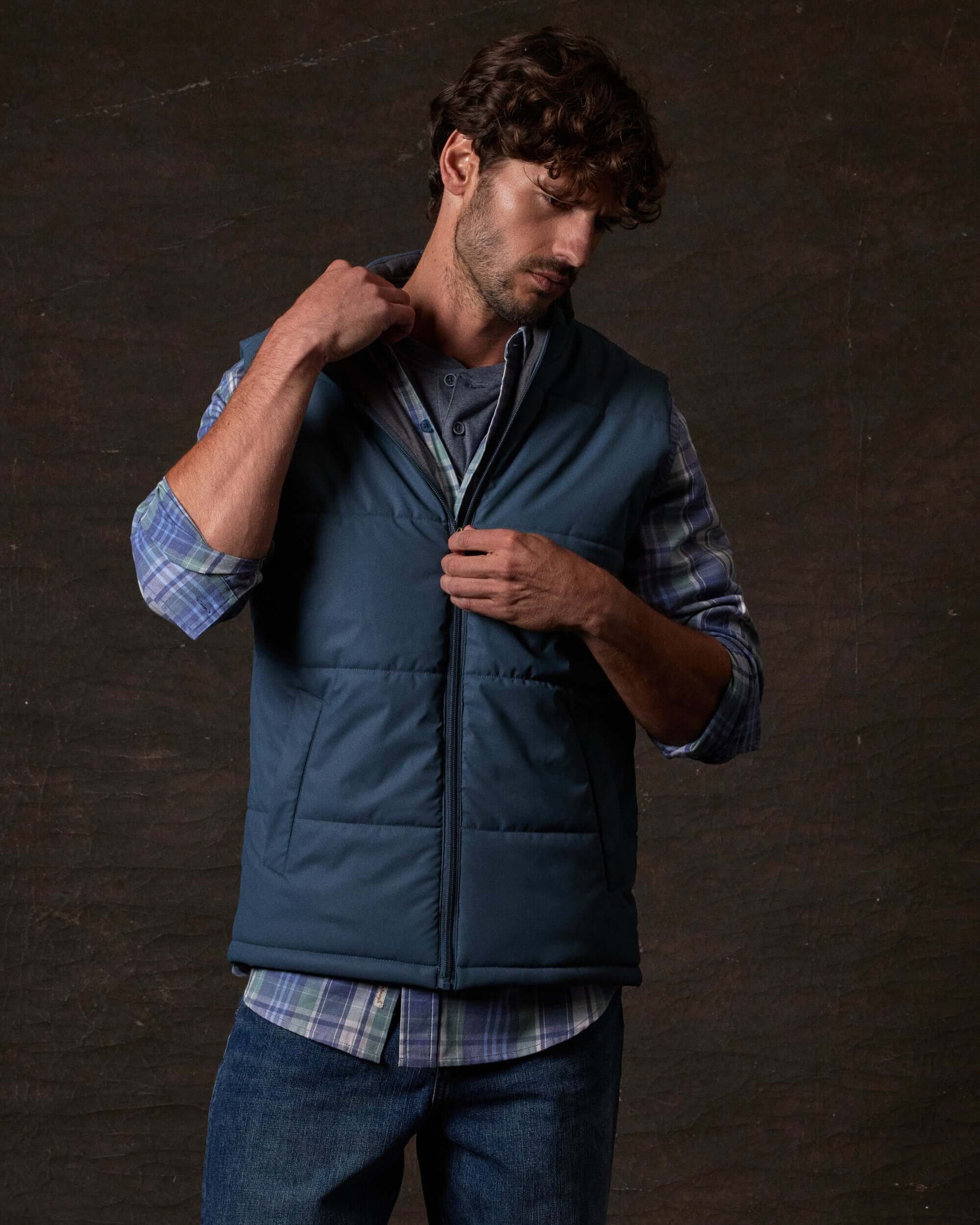 Model wearing a Matte Coated Shell Puffer Vest in Slate Blue, showcasing its sleek design and zip-front closure.