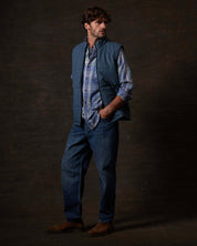 Model wearing Matte Coated Shell Puffer Vest in Slate Blue paired with plaid shirt and jeans.
