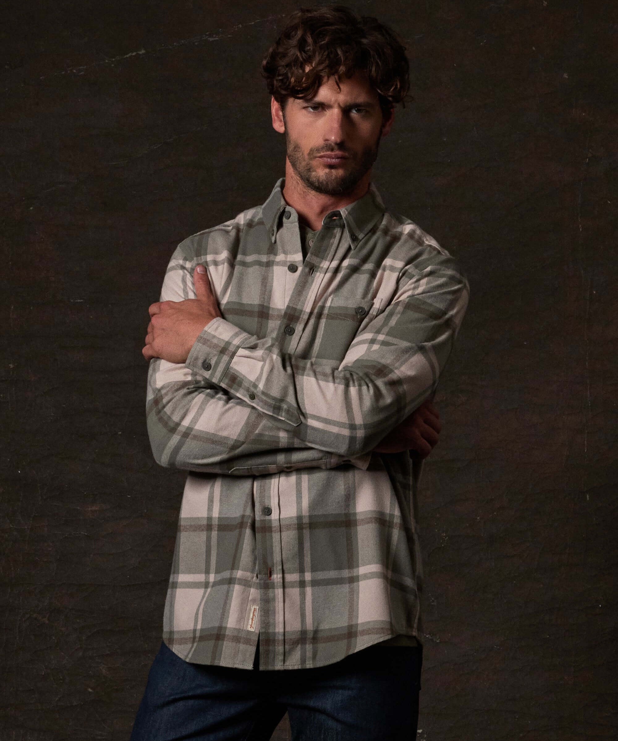 Long Sleeve Brushed Flannel in Kalamata, featured on a model in a rustic setting with a button-down collar.