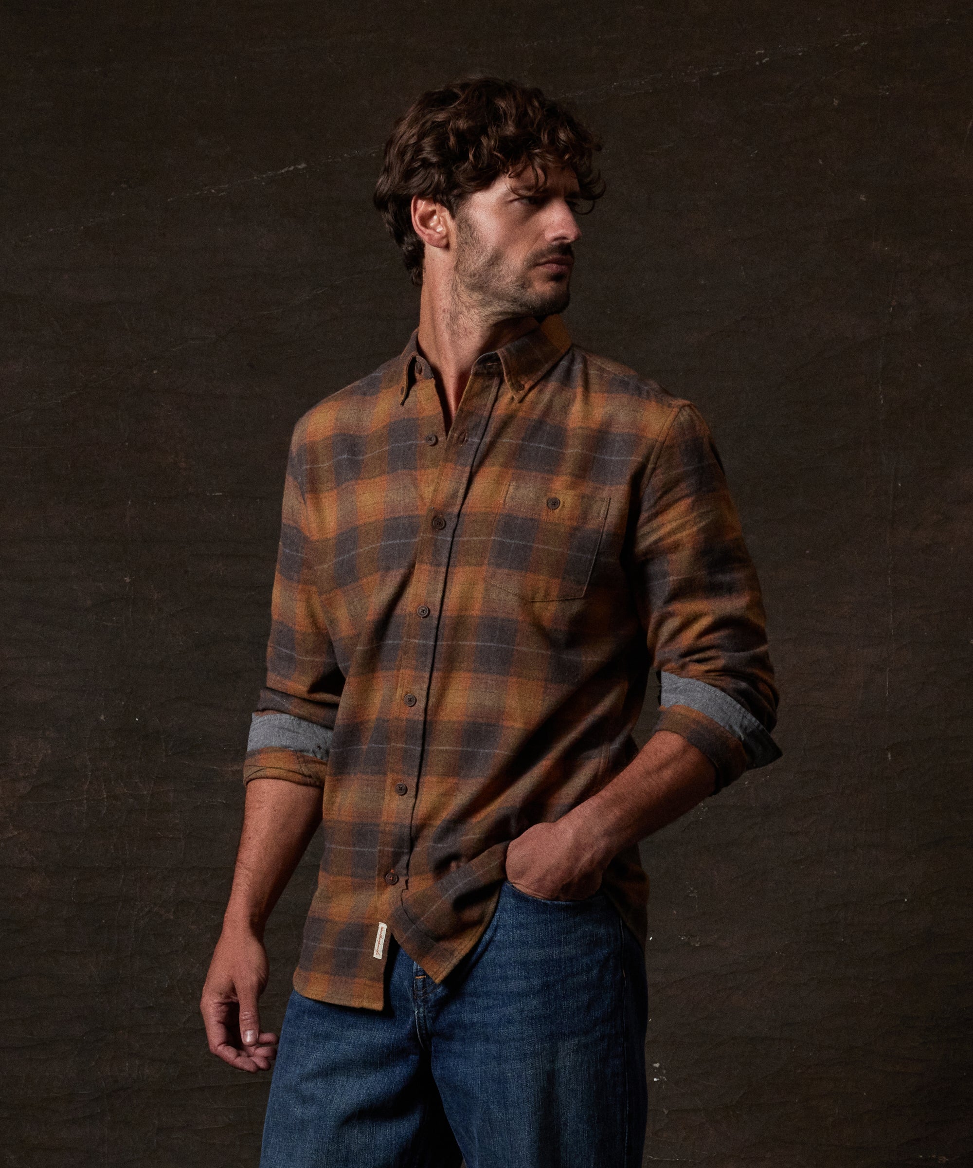 Long Sleeve Brushed Flannel in Pumpkin Spice worn by a man styled with jeans and set against a dark background.