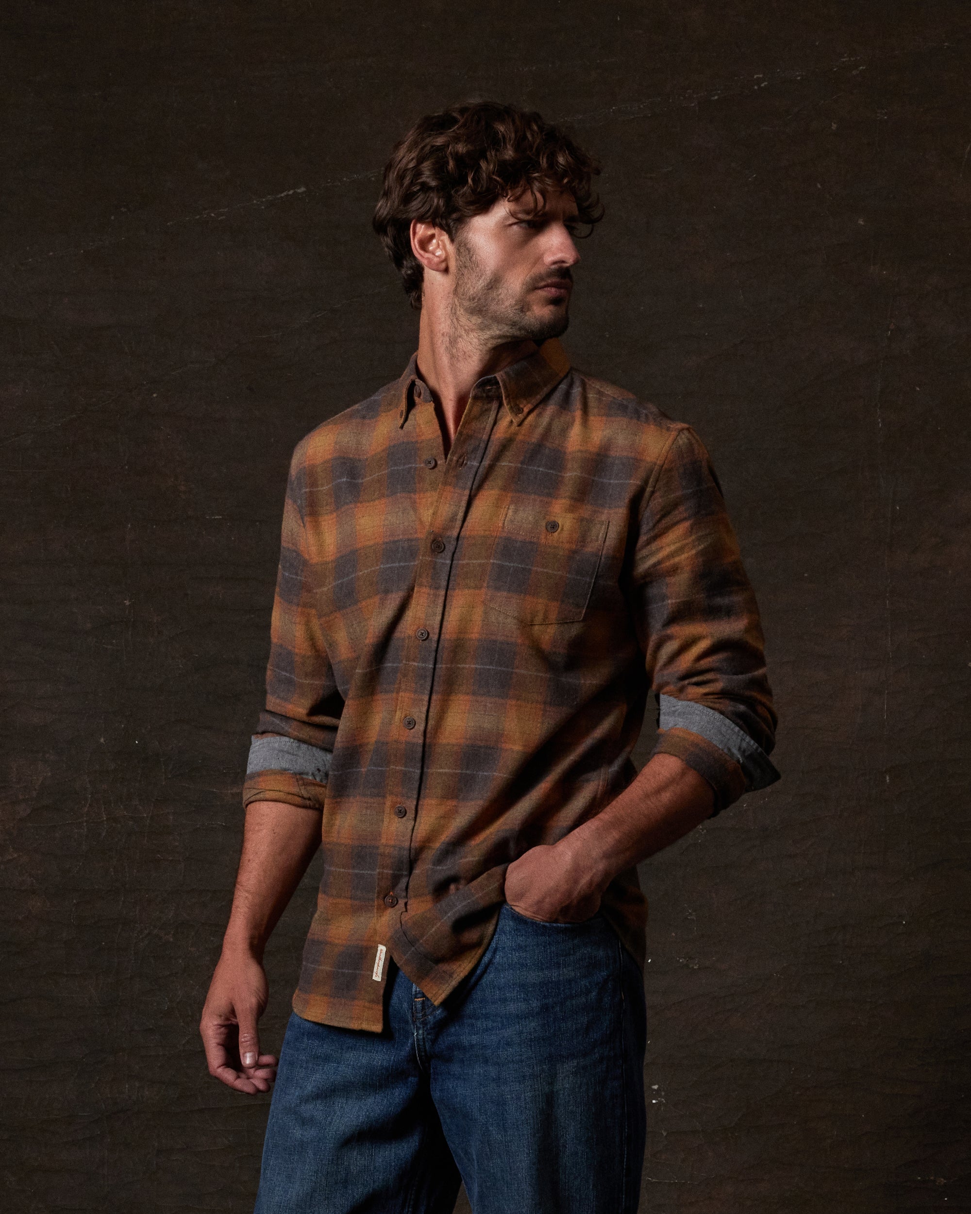 Long Sleeve Brushed Flannel in Pumpkin Spice worn by a man styled with jeans and set against a dark background.