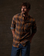 Long Sleeve Brushed Flannel in Pumpkin Spice modeled by man with curly hair, featuring a button-down collar.