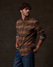 Model wearing Long Sleeve Brushed Flannel in Pumpkin Spice, showcasing a rugged, vintage style with a button-down collar.