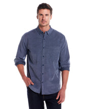Long Sleeve Pebble Corduroy Shirt in Ensign Blue worn by model in casual setting, showcasing button-down collar and cuffed sleeves.