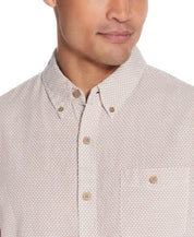 Close-up of a man wearing a Mini Geo Print Shirt In Cinnamon Stick with a relaxed fit and button detail.