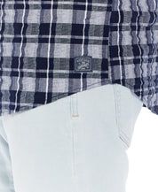 Close-up of the Plaid Seersucker Shirt In Shadow, featuring a vintage label and lightweight fabric pattern.