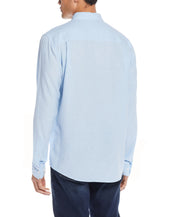 Back view of a man wearing a Long Sleeve Linen Cotton Shirt In Cerulean, showcasing the relaxed fit and lightweight design.