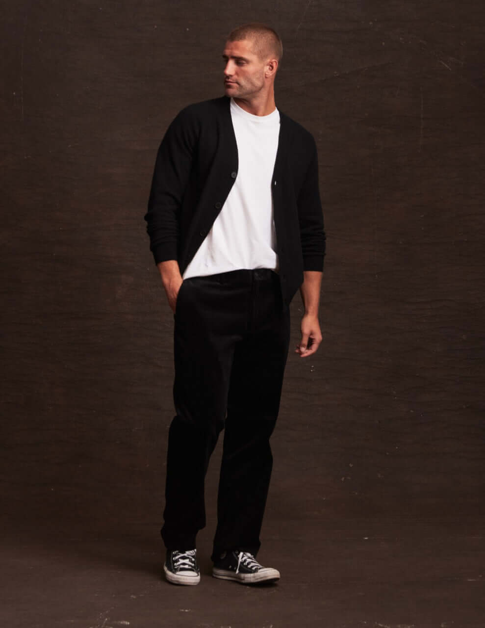 Stylish man in black cashmere cardigan with white t-shirt, showcasing lightweight warmth for autumn fashion.