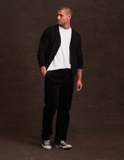 Stylish man in black cashmere cardigan with white t-shirt, showcasing lightweight warmth for autumn fashion.