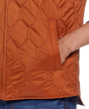 Close-up of hexagon quilted lightweight vest in caramel cafe, featuring front zip closure and side pockets.