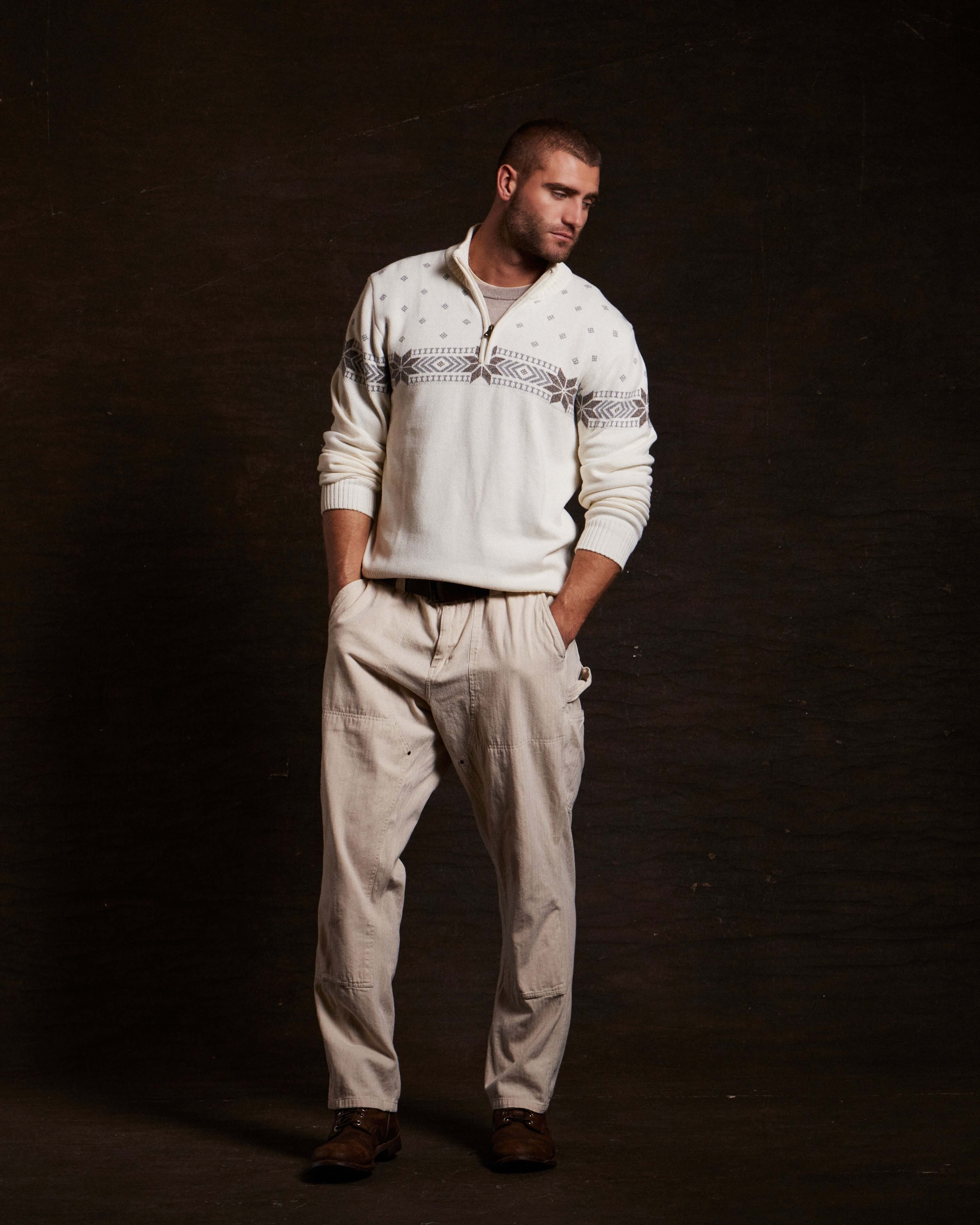 Model wearing Holiday Snowflake Quarter Zip Sweater in vanilla with pants, showcasing stylish winter fashion.