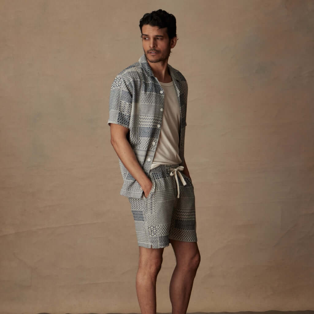 Man in a cream and navy jacquard resort shirt and matching shorts, relaxed vacation style, 100% cotton fabric.