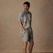 Man in a cream and navy jacquard resort shirt and matching shorts, relaxed vacation style, 100% cotton fabric.
