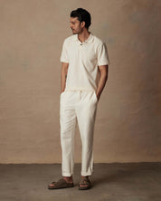 Model wearing white linen blend drawstring pants with a polo shirt, highlighting a relaxed fit and casual style.