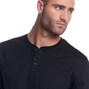 Model wearing a black long sleeve brushed jersey henley with a modern fit and button details.