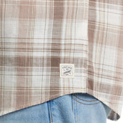 Close-up of Long Sleeve Faux Linen Plaid Button Down shirt in Natural, featuring a vintage tag and cuffed detail.