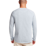 Man wearing a dusty blue long sleeve raglan sweatshirt, showcasing the back design and classic fit.