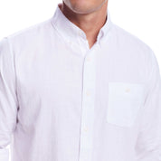 Close-up of a man wearing a long sleeve white cotton twill shirt with a button-down collar and chest pocket.