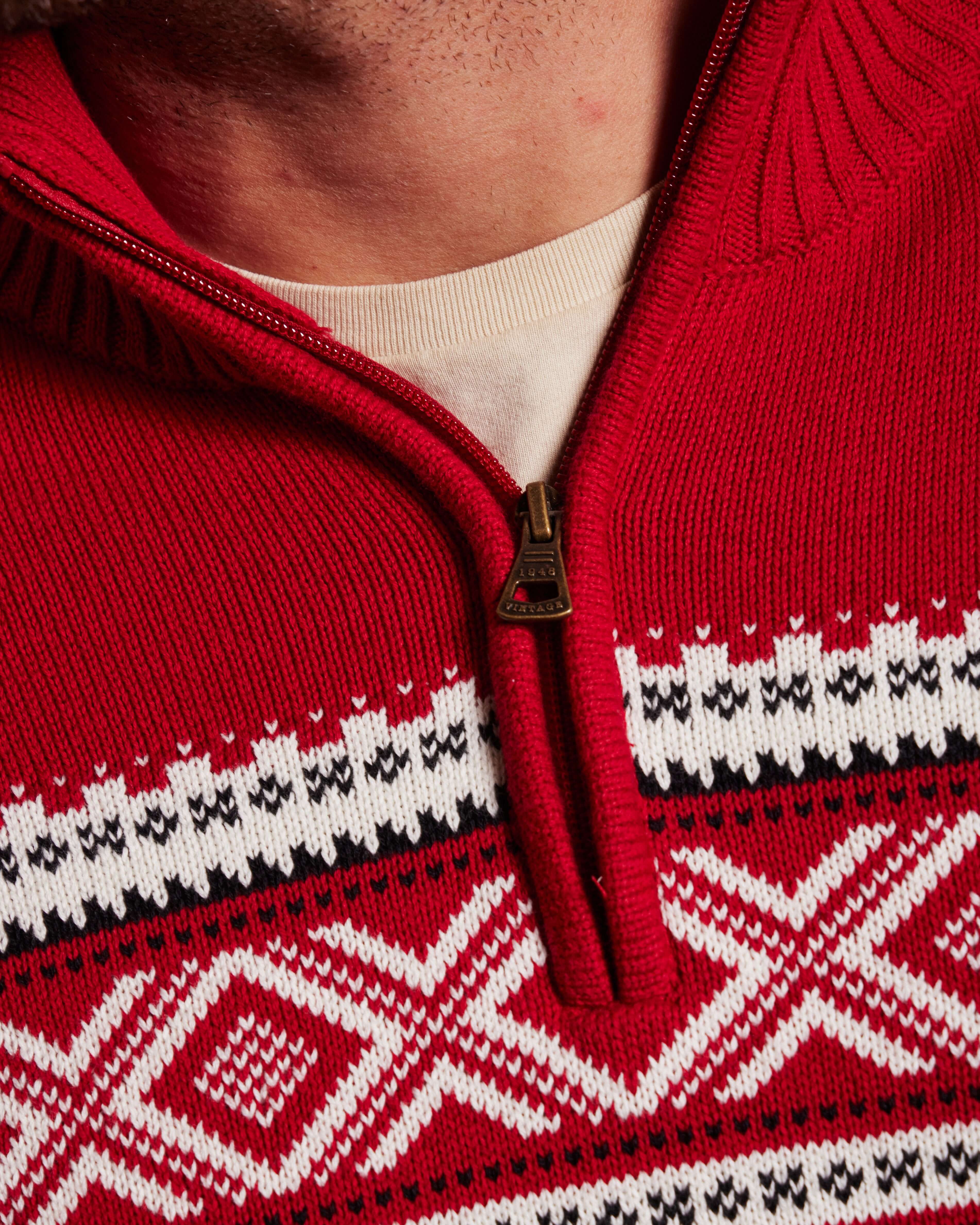 Close-up of Nordic Quarter Zip Sweater in Tartan Red, featuring a unique patterned chest and quarter zip detail.