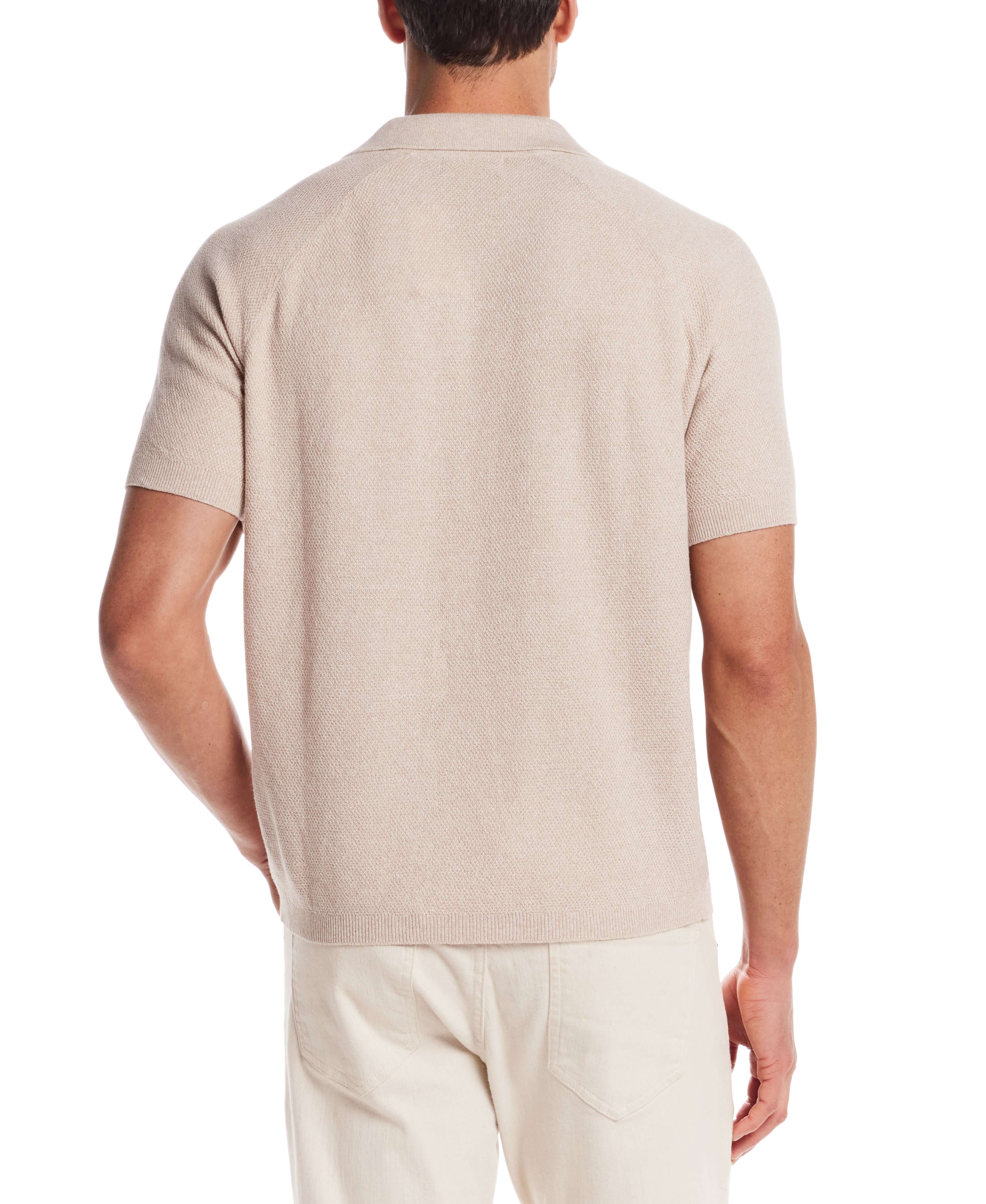 Back view of a lightweight open collar polo sweater in oat twist, showcasing its ribbed cuffs and soft texture.