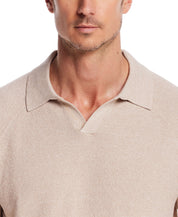Close-up of a man wearing an open collar polo sweater in oat twist, showcasing its textured fabric and relaxed fit.
