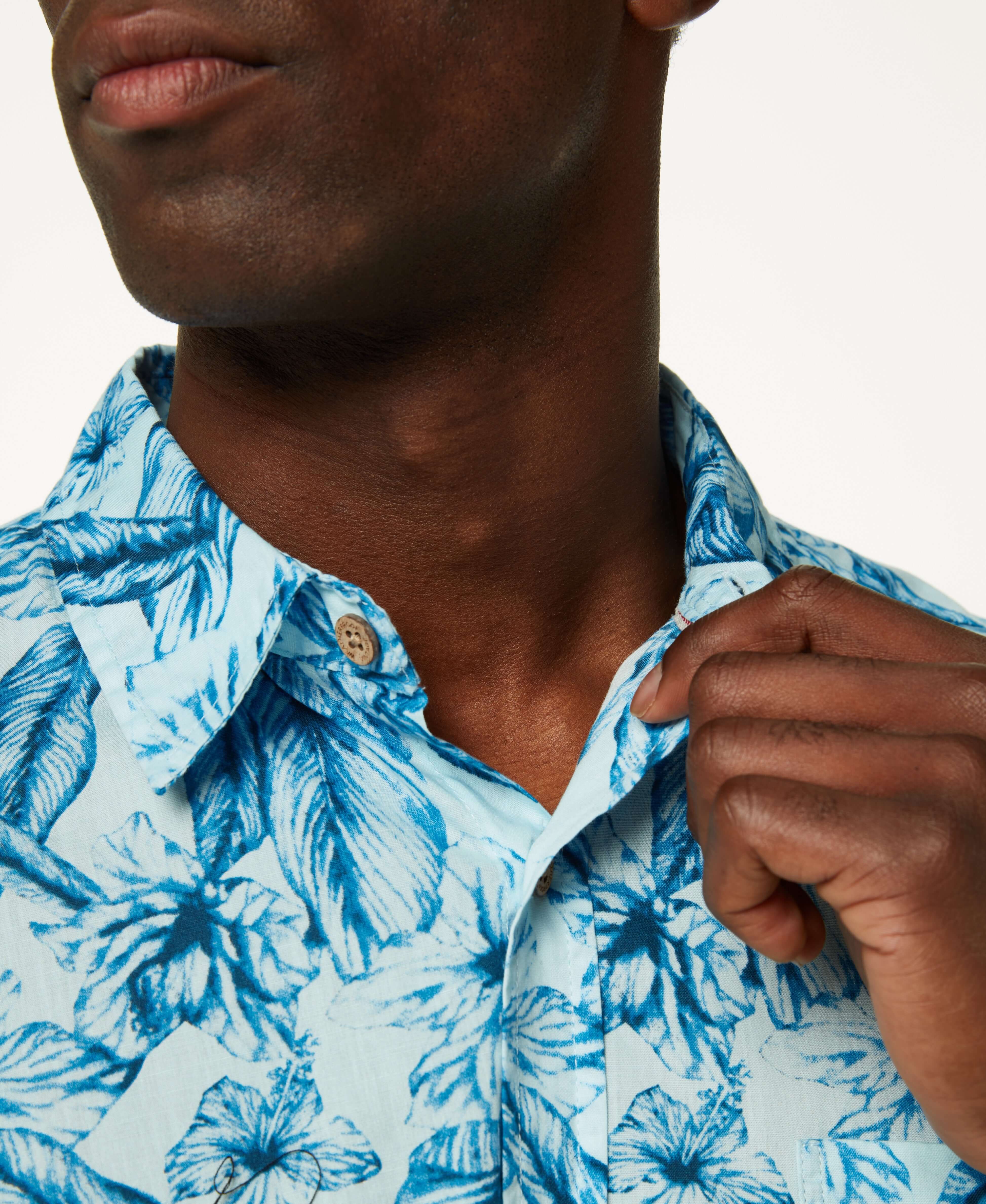Close-up of model wearing Poplin Floral Print In Sky Blue shirt, showcasing its button-down collar and soft cotton fabric.