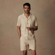 Model wearing a cream short sleeve corduroy cabana shirt, perfect for beach vacations and paired with matching shorts.