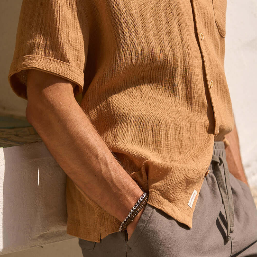 Short sleeve cotton linen Airtex shirt in biscuit color on a model, featuring a camp collar and button-down chest pocket.