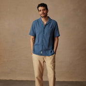 Model wearing a Short Sleeve Cotton Linen Airtex Shirt in Blue Ashes, styled for a casual vacation look.