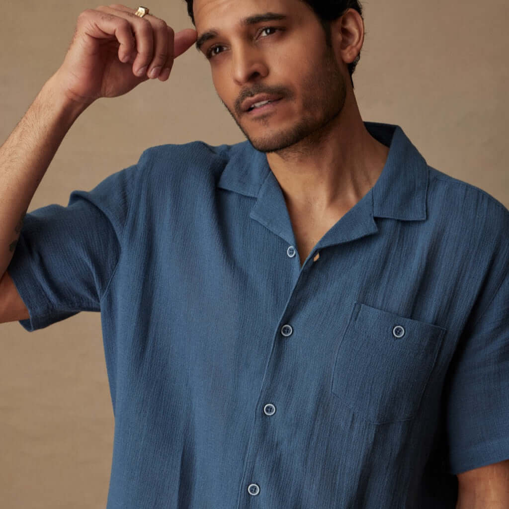 Model wearing a Short Sleeve Cotton Linen Airtex Shirt in Blue Ashes, showcasing the camp collar and button-down chest pocket.