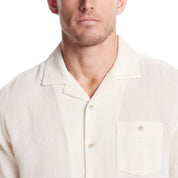 Men's short sleeve cream cotton linen Airtex shirt featuring camp collar and button chest pocket.
