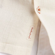 Close-up of cream short sleeve Airtex shirt showcasing the camp collar and button details.