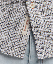 Close-up of a patterned cotton poplin shirt showcasing button detail and label, ideal for classic tailoring and polished style.