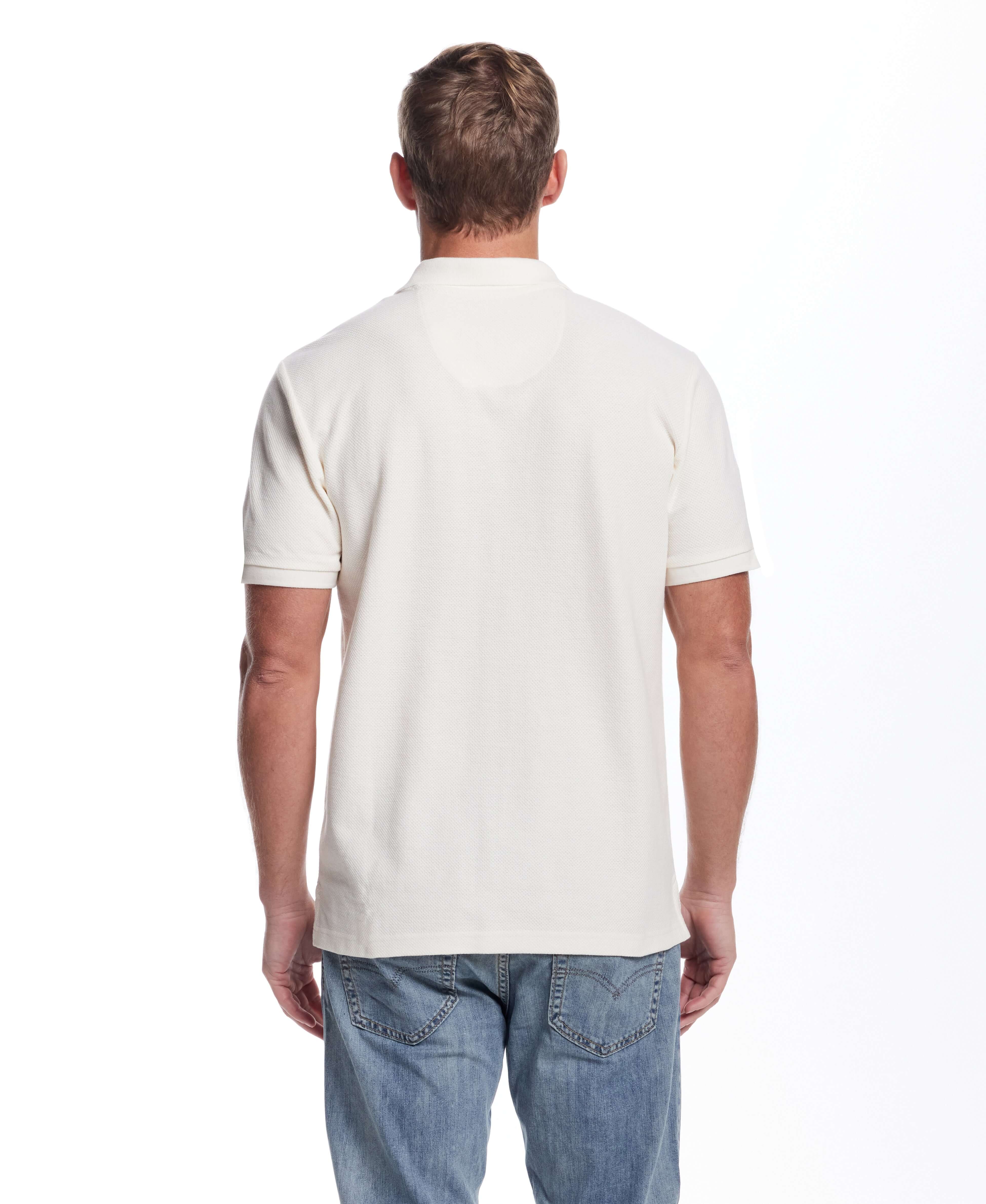Back view of a man wearing a short sleeve ivory honeycomb pique polo shirt, showcasing a classic fit and ribbed collar.