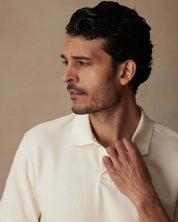 Model wearing an ivory short sleeve honeycomb pique polo shirt with a classic fit and ribbed collar.