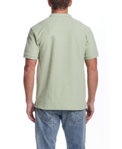 Back view of a light green short sleeve honeycomb pique polo shirt on a model, showcasing classic fit and ribbed cuffs.