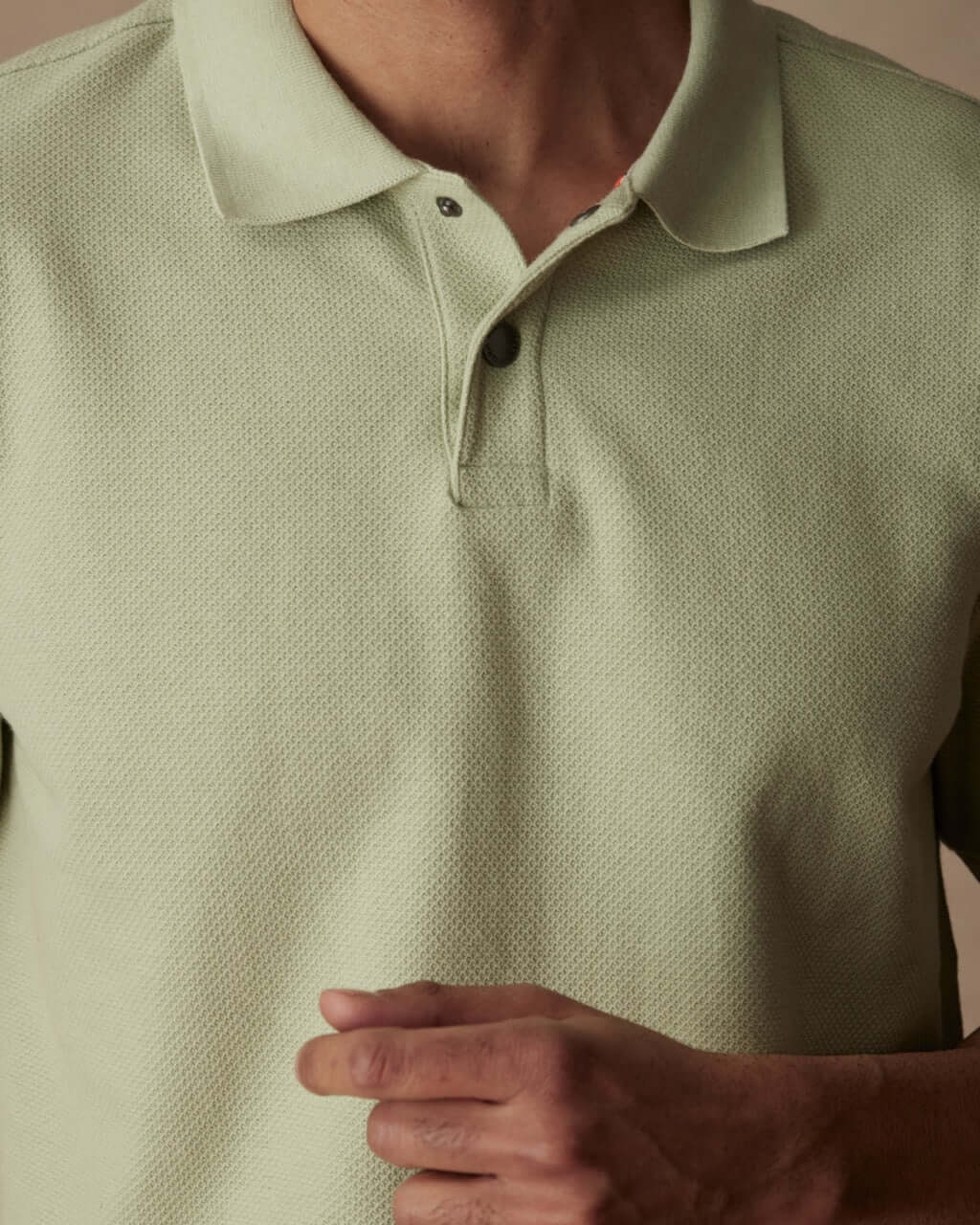 Light green short sleeve honeycomb pique polo shirt with ribbed collar and snap placket by model.